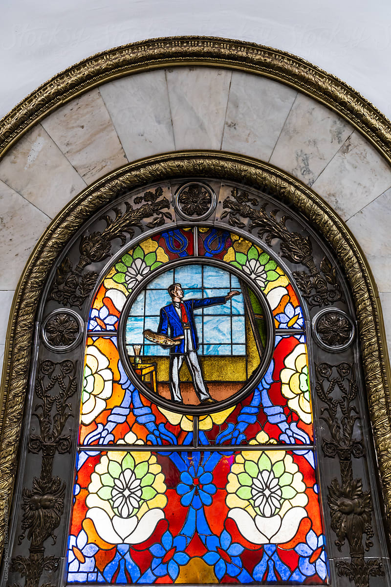 Detail of stained glass art piece picturing a painter at his workshop
