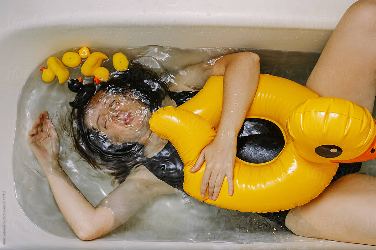 A woman bathes in the bathtub and has fun