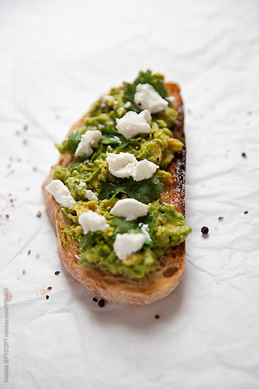 Close up of smashed avocado on toast with feta - goats cheese  for breakfast