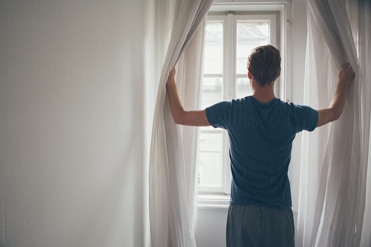 Man Opening the Curtains