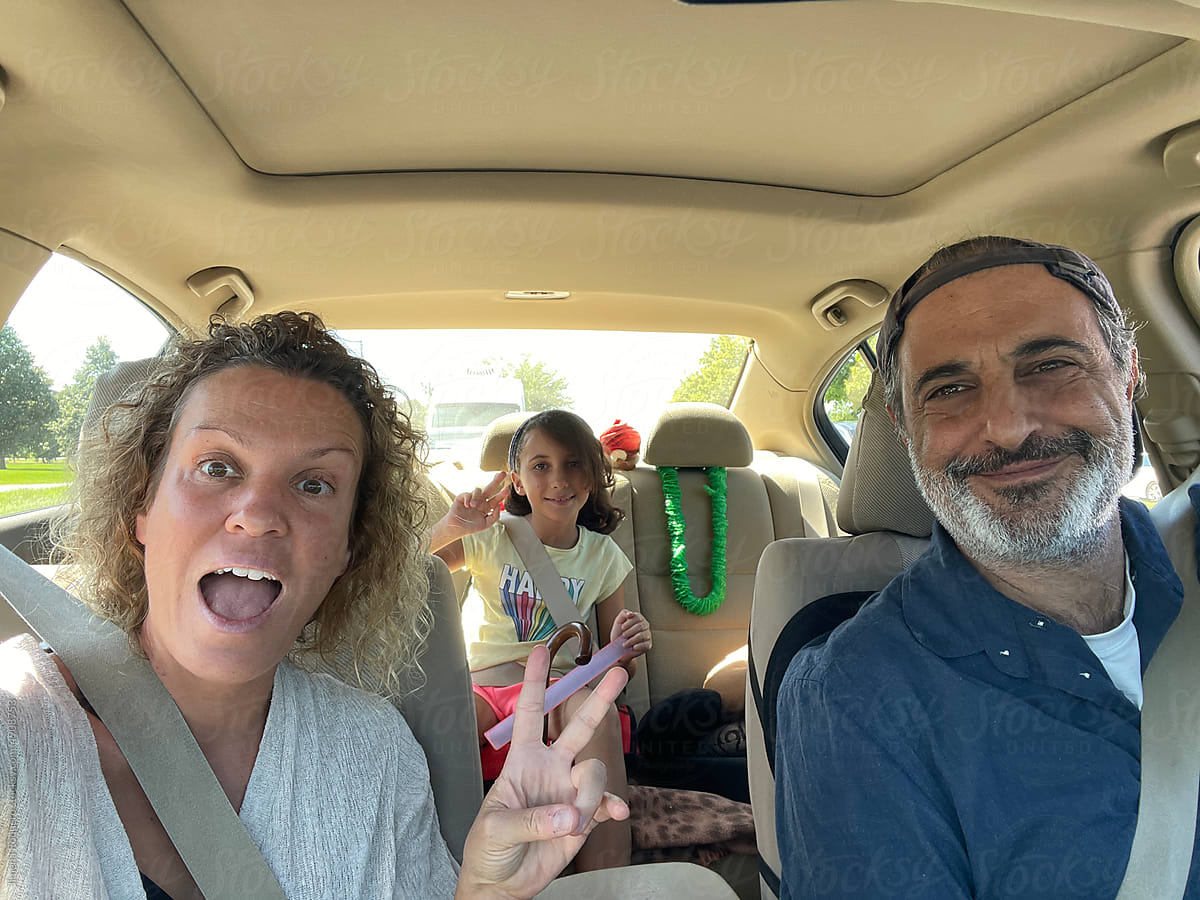UGC mobile photo selfie of family inside a car smiling at camera