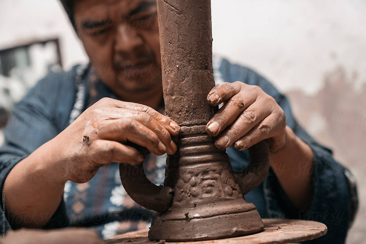 Mexican artisan sculpting with mud
