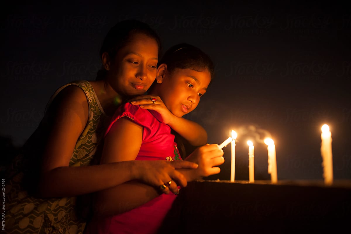 Teenage girl and young woman lighting candle at night  in outdoor