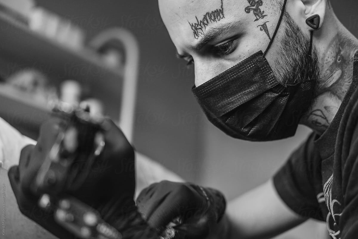 Tattoo artist drawing on client\'s skin