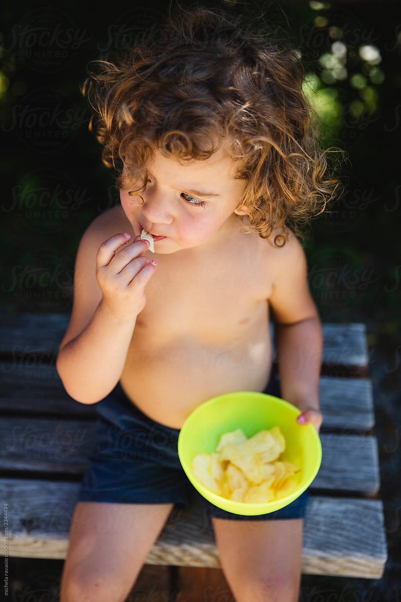 Little baby girl eating chips
