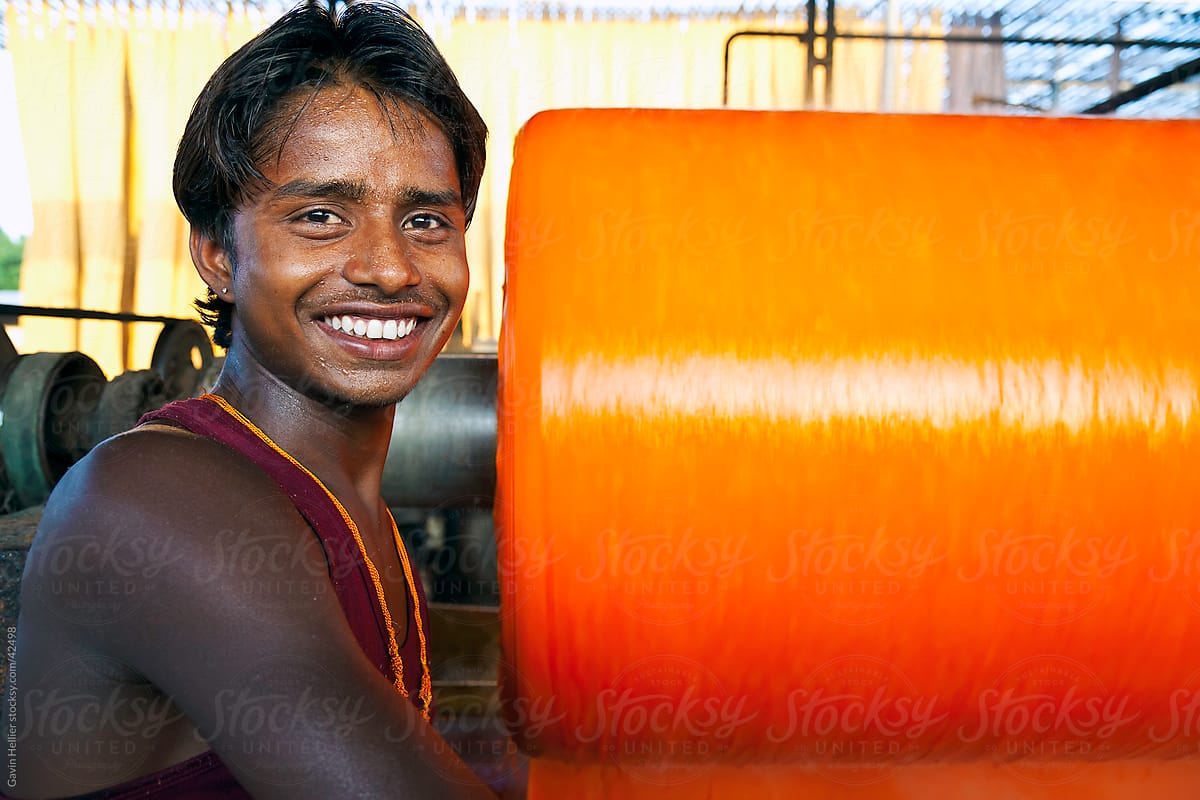 Portrait of a factory worker, Newly dyed fabric being washed and rolled, Sari garment factory, Jaipur, Rajasthan, India