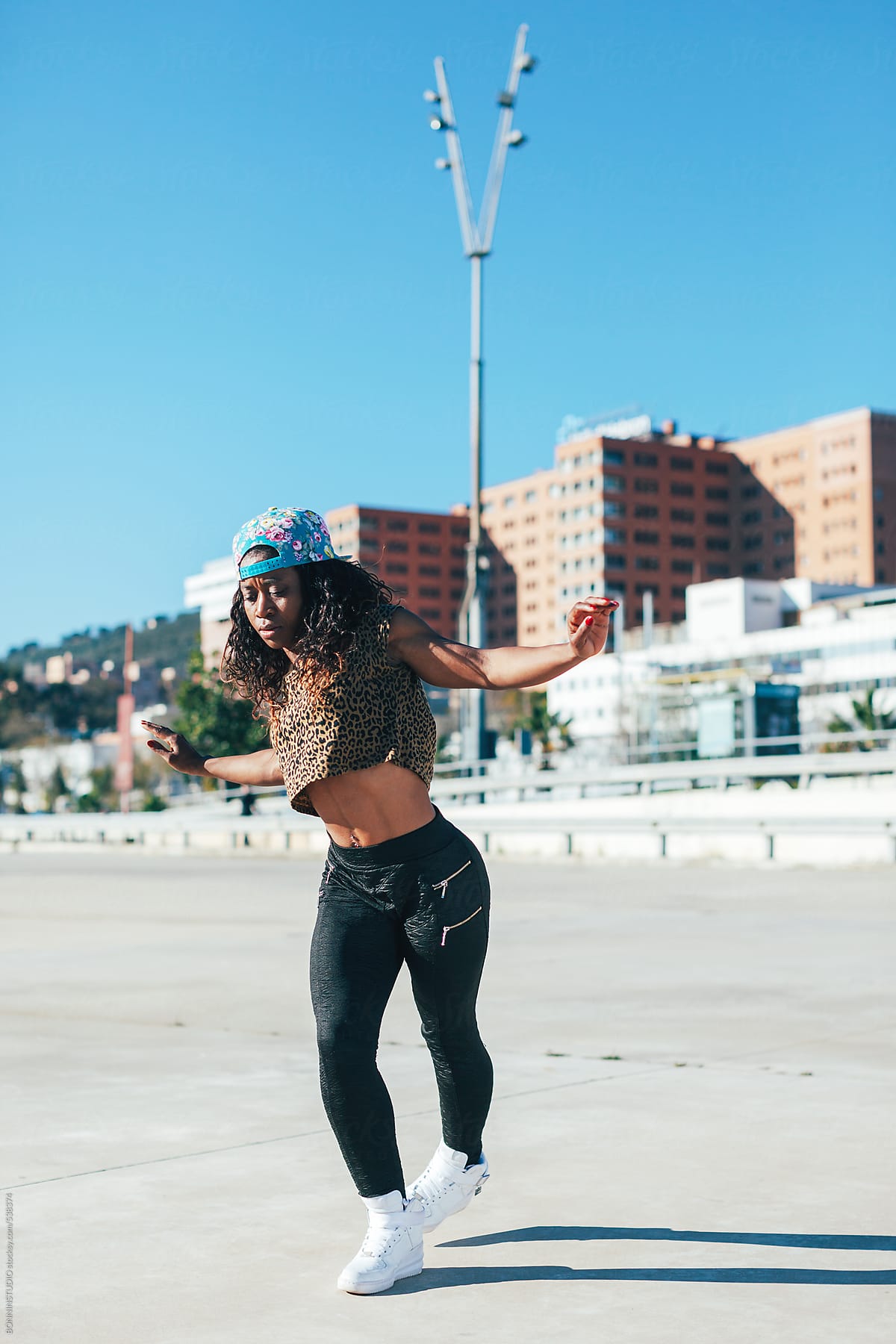 Young African American Woman Performing Break Dance In A City. by Stocksy  Contributor BONNINSTUDIO  - Stocksy