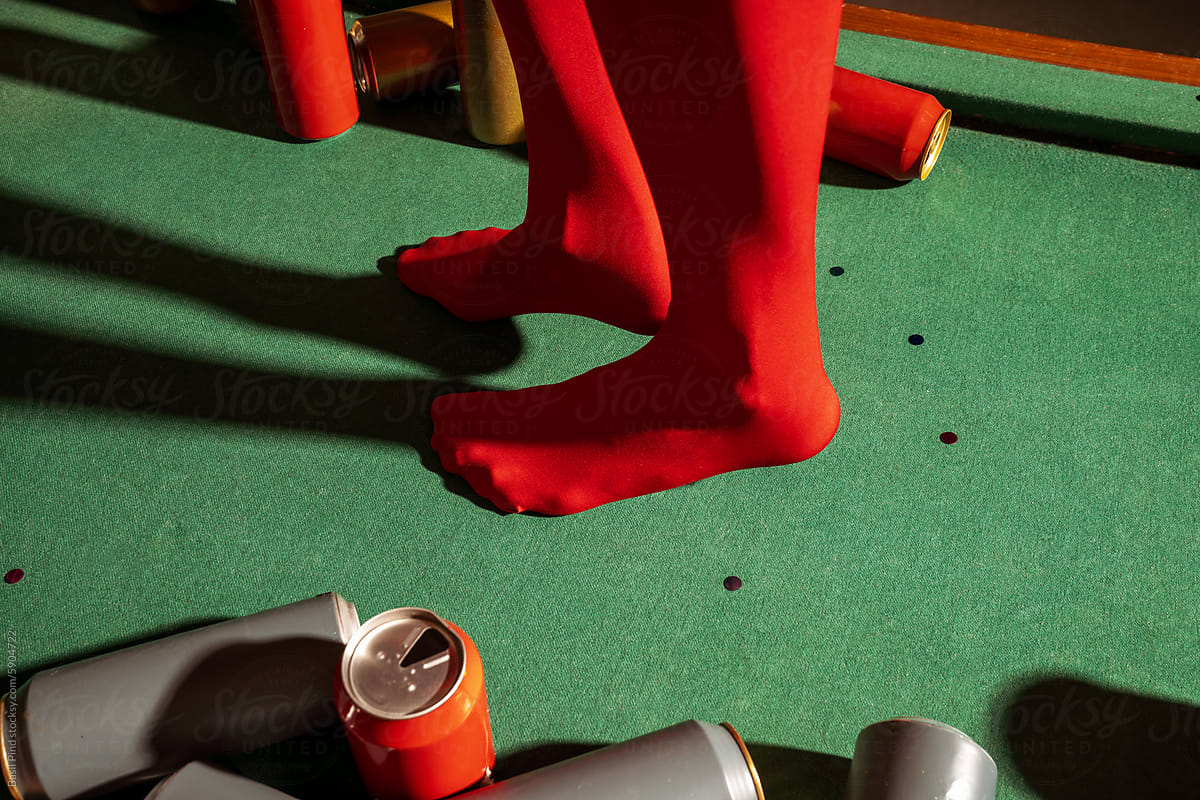Red Tights on Green Pool Table with Scattered Cans