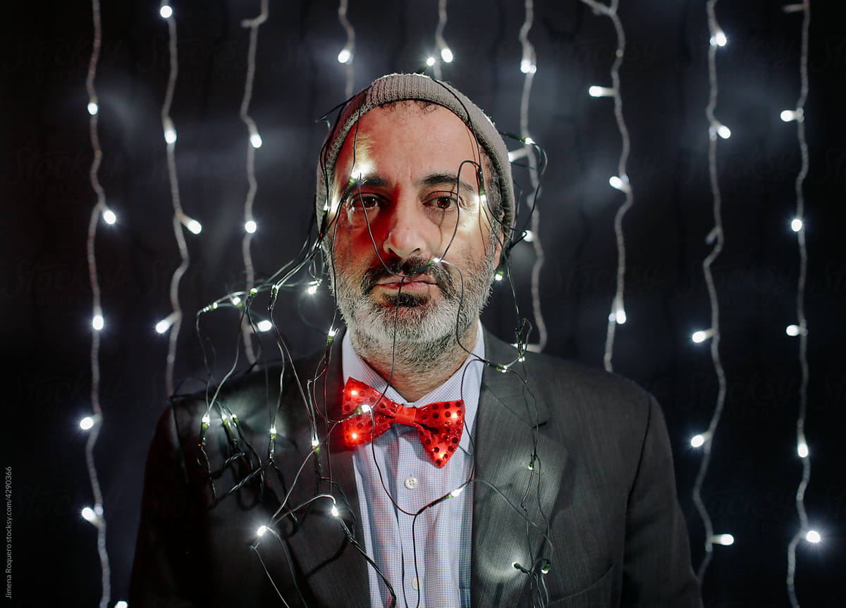 Man in bow tie with Christmas lights on his head