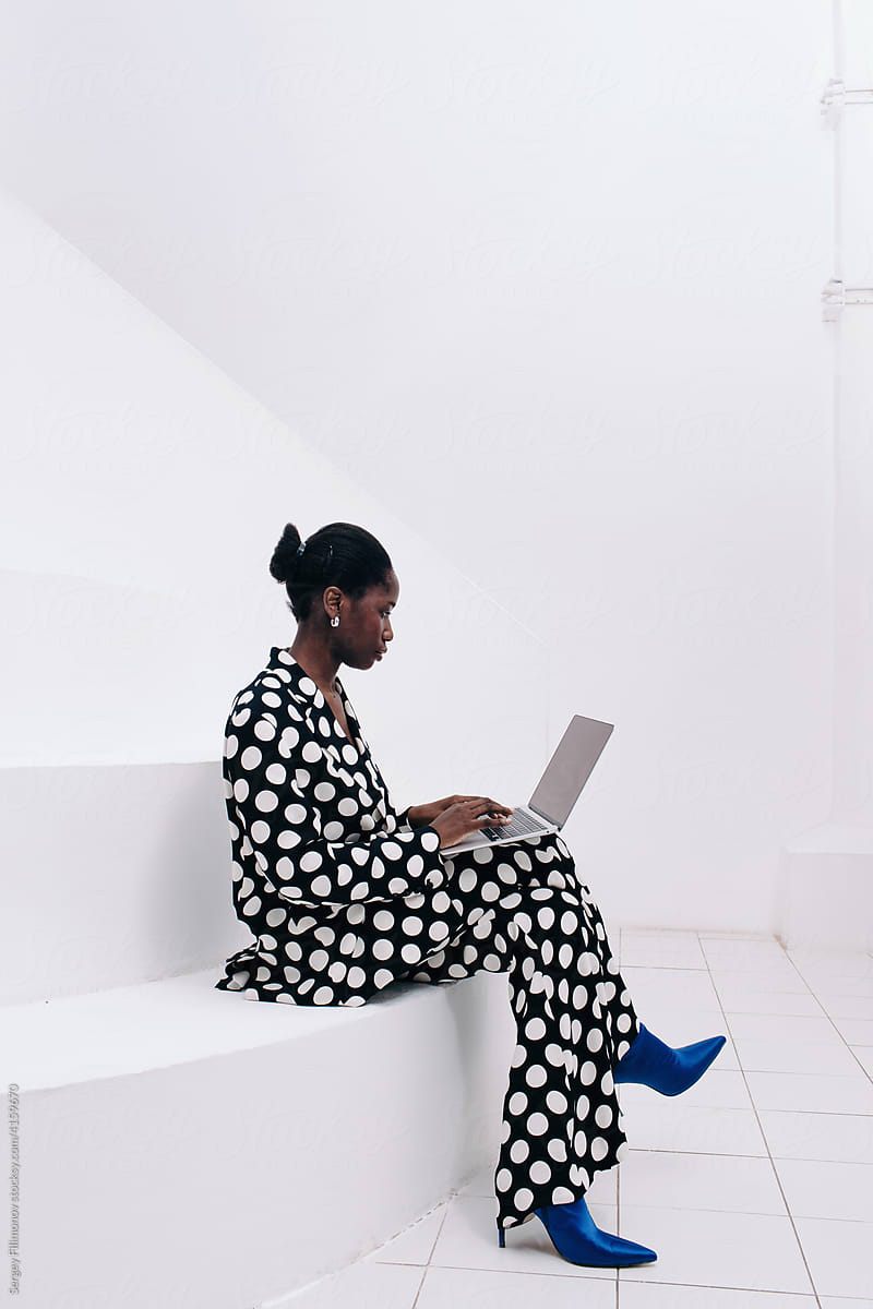 Black woman using laptop in minimal interior