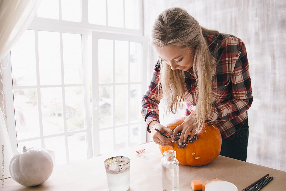 Woman decorating pumpkin using decoupage technique
