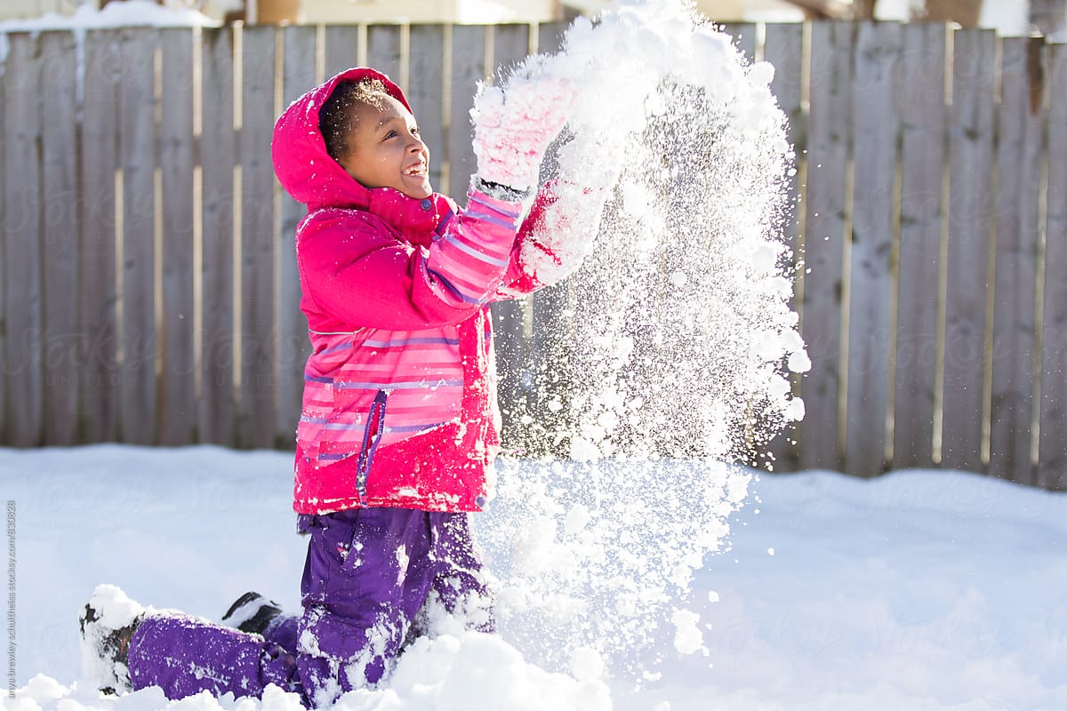 Tween girl throwing snow happily into the air