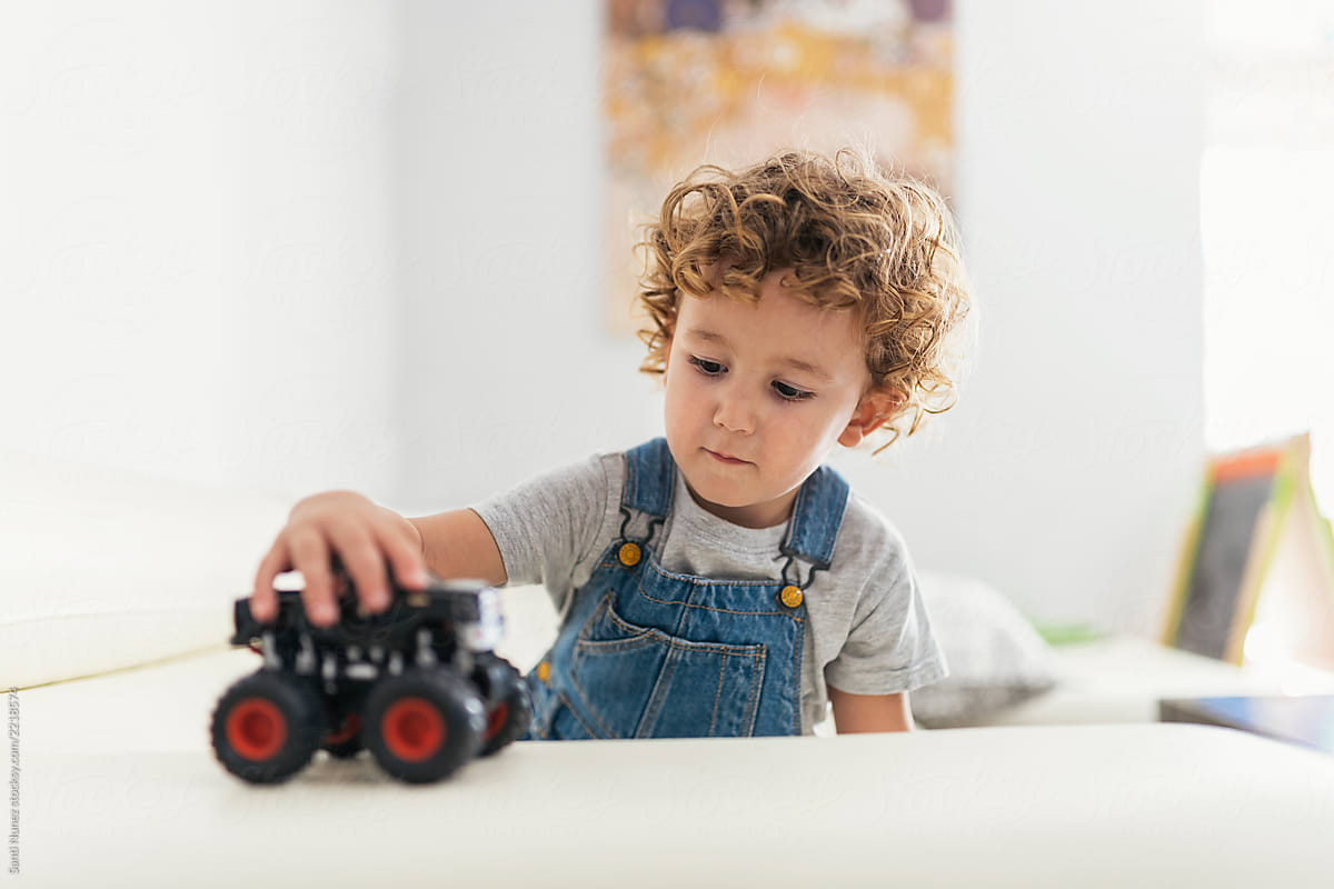 Portrait of cute child playing with car toy