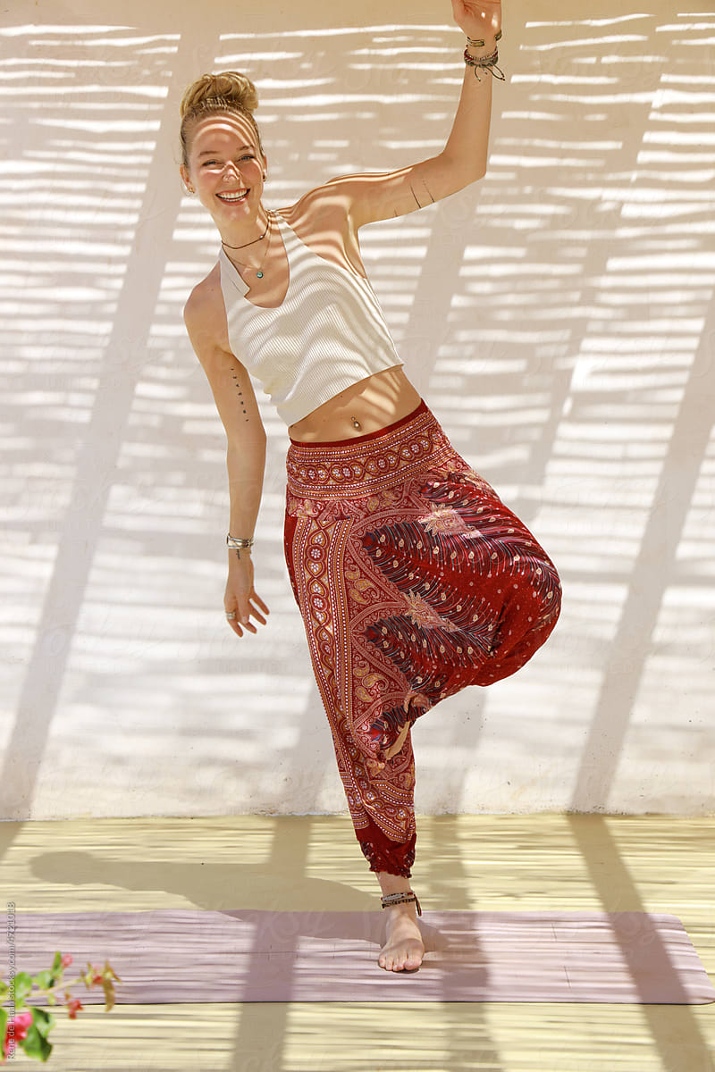 young woman losing her balance doing yoga pose