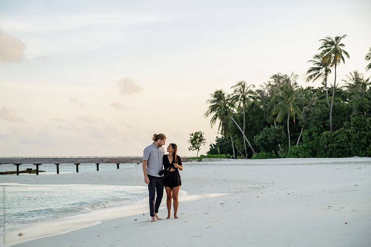 Couple walking alongside Maldive beach