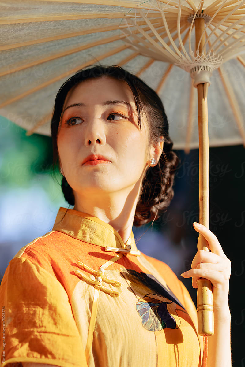 Elegant Asian woman with umbrella on hand