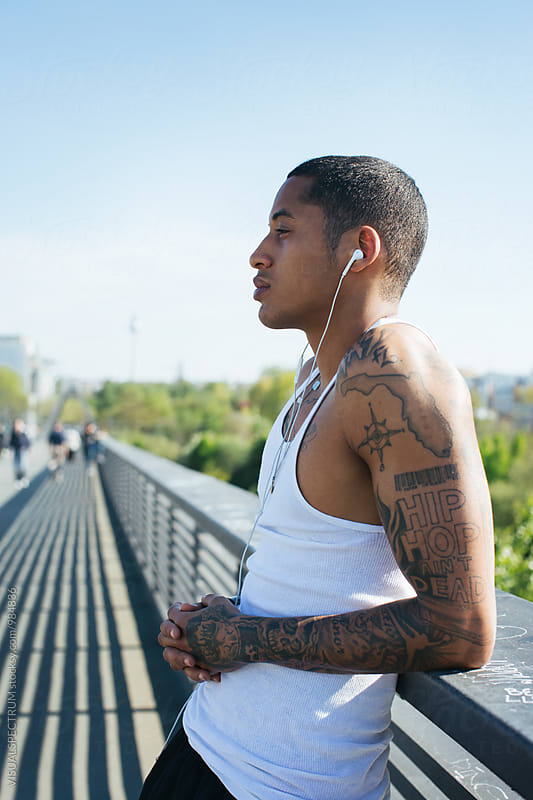 Profile of Young Mixed Race Man in White Tank Top Listening to Music With Earphones