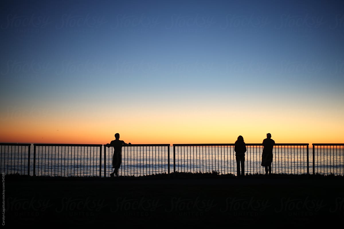 Three silhouettes watching the sunset in Santa Cruz