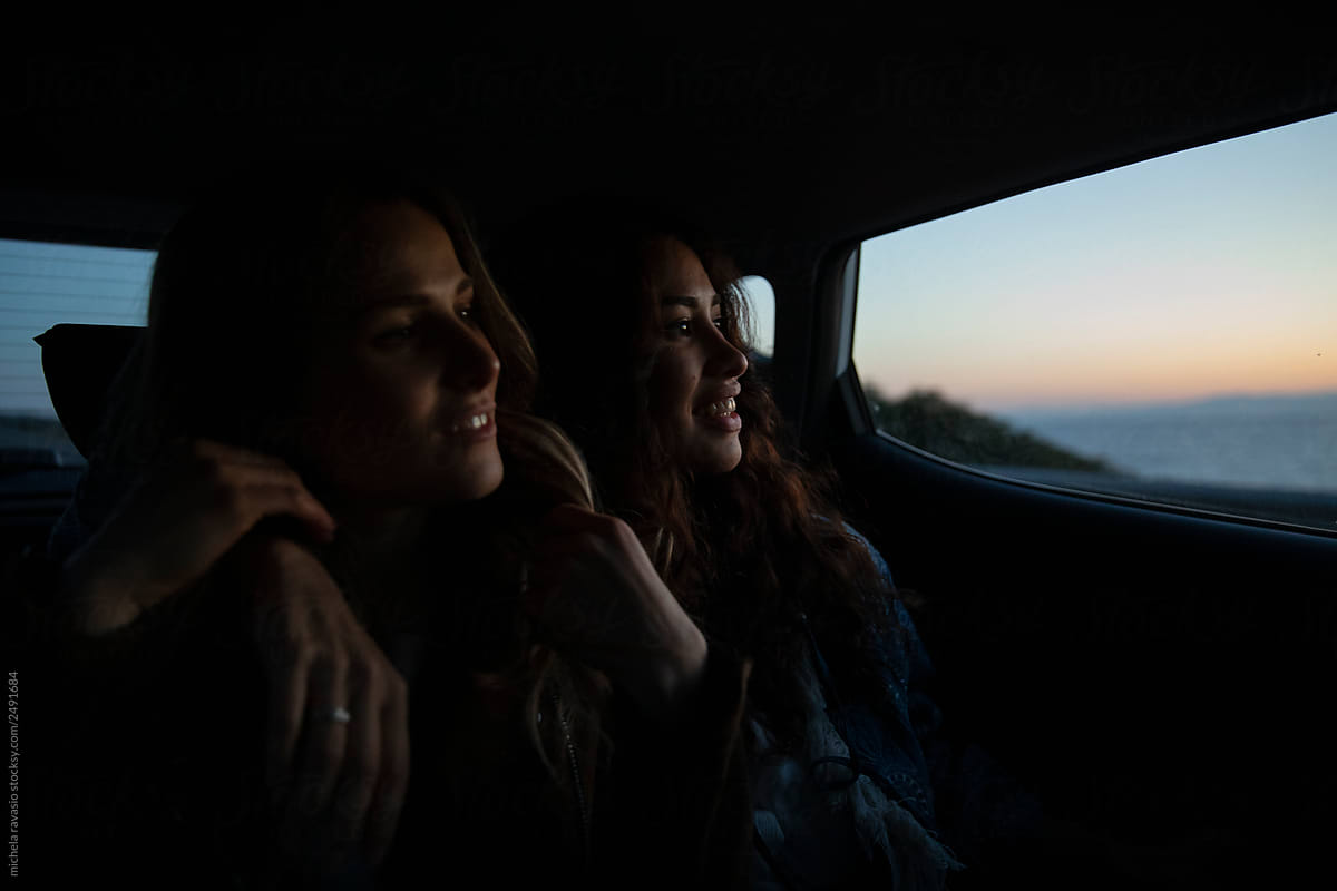 Two Girls Sitting In The Car Enjoying The Last Lights Of The Day