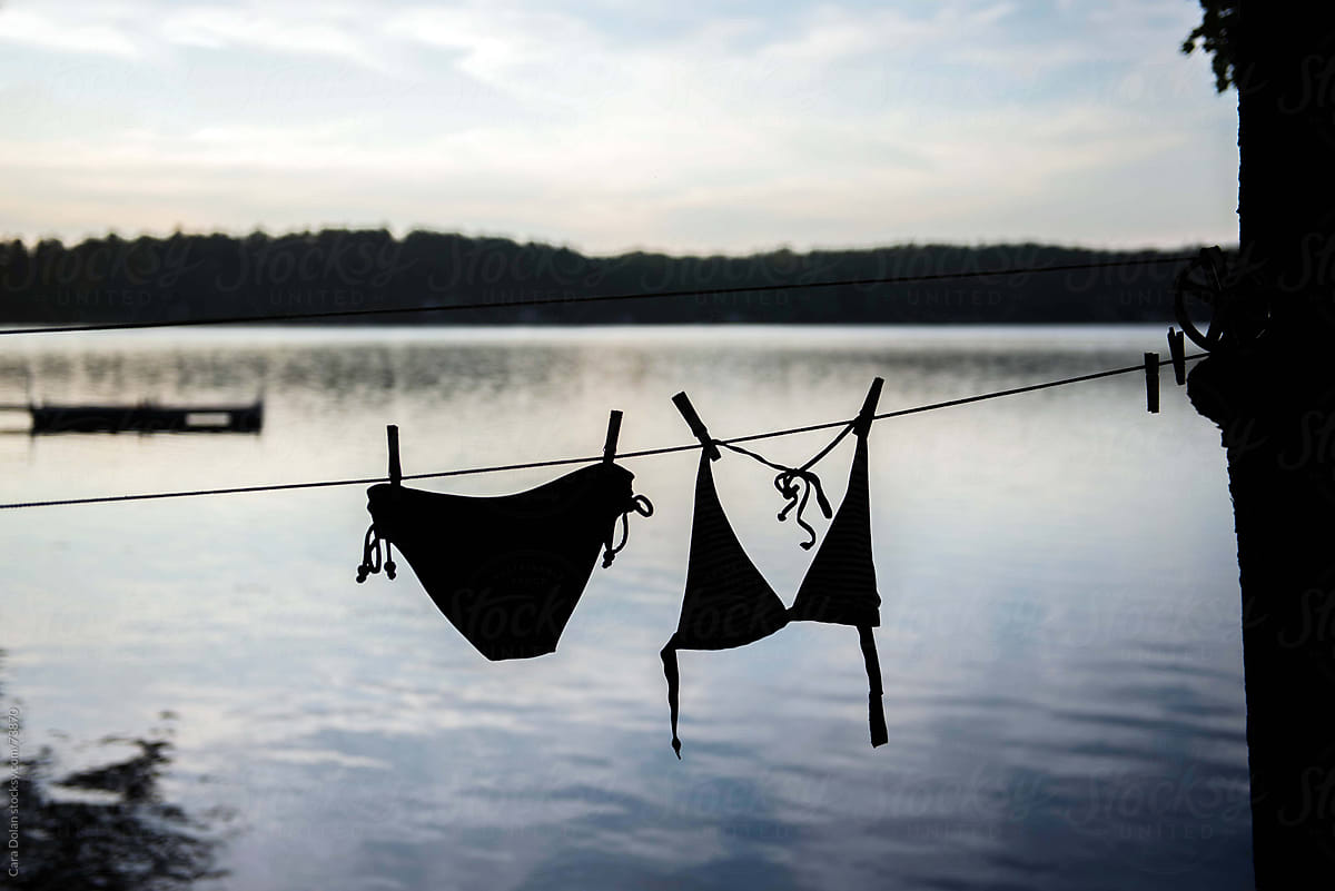 Woman\'s Bikini Hangs on the Line to Dry by the Lake