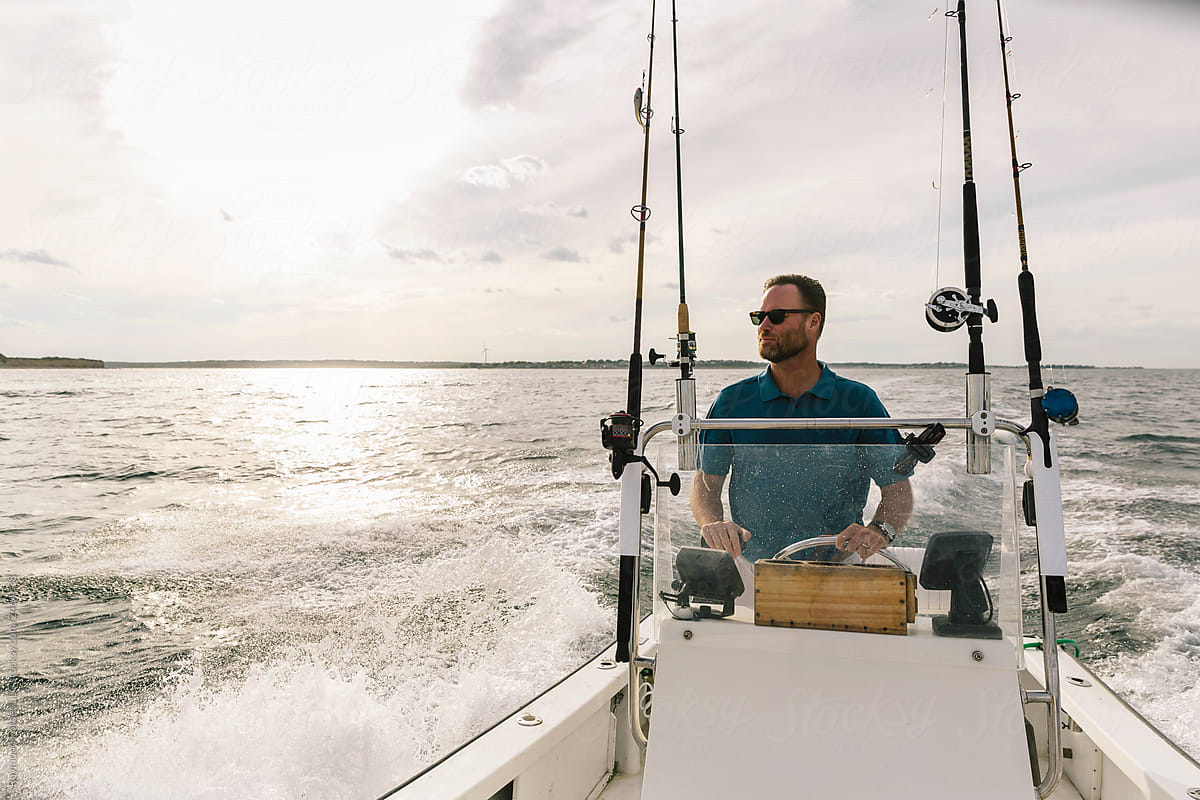 Man  Driving  Fishing Boat Scanning Horizon for fish
