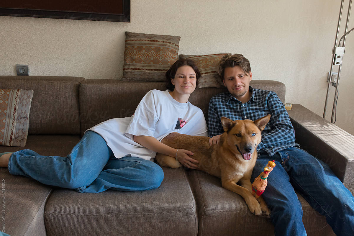 a couple with a dog on the couch