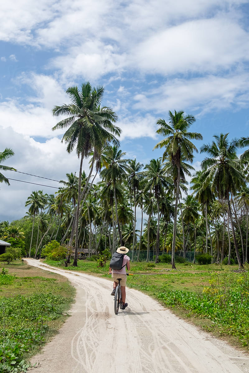 Male riding a bicycle on tropical La Digue Island - Seychelles