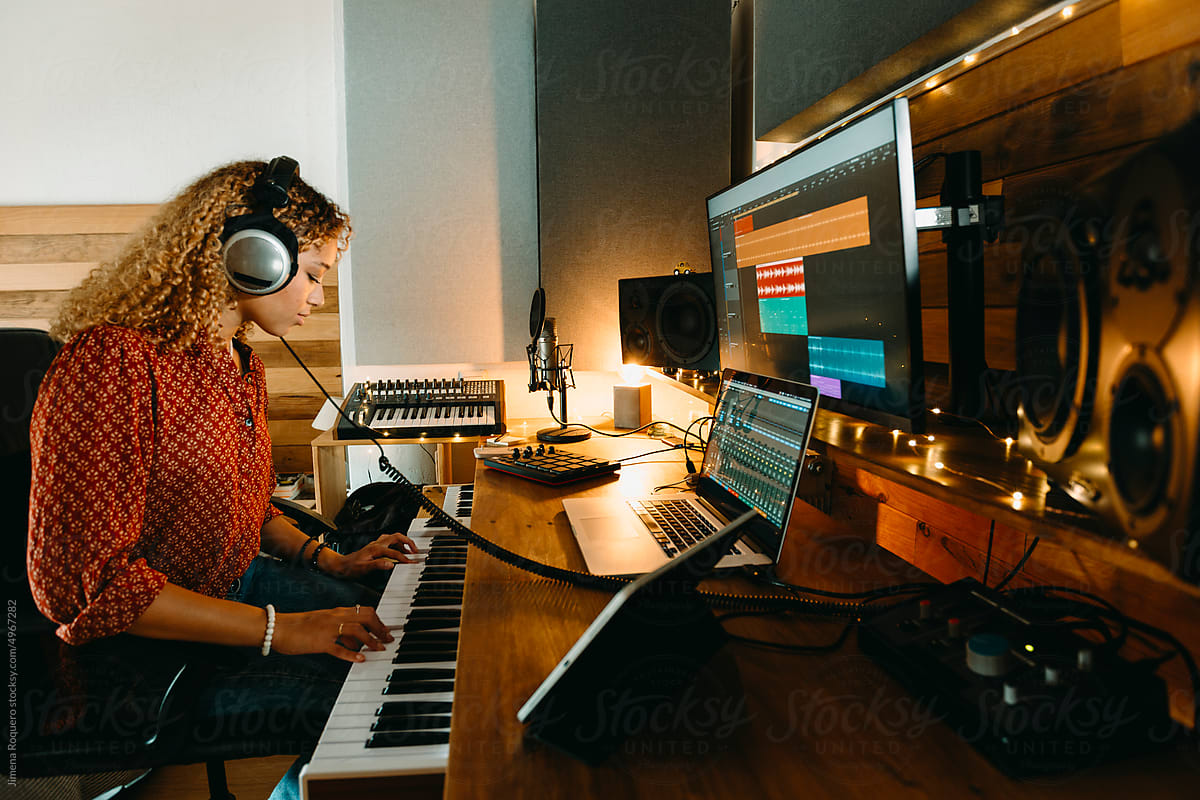 Music producer working at home studio using keyboard controller