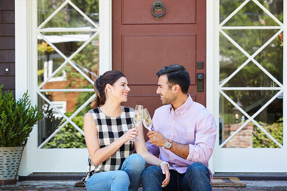 Millennial couple drinking champagne celebrating their first home purchase