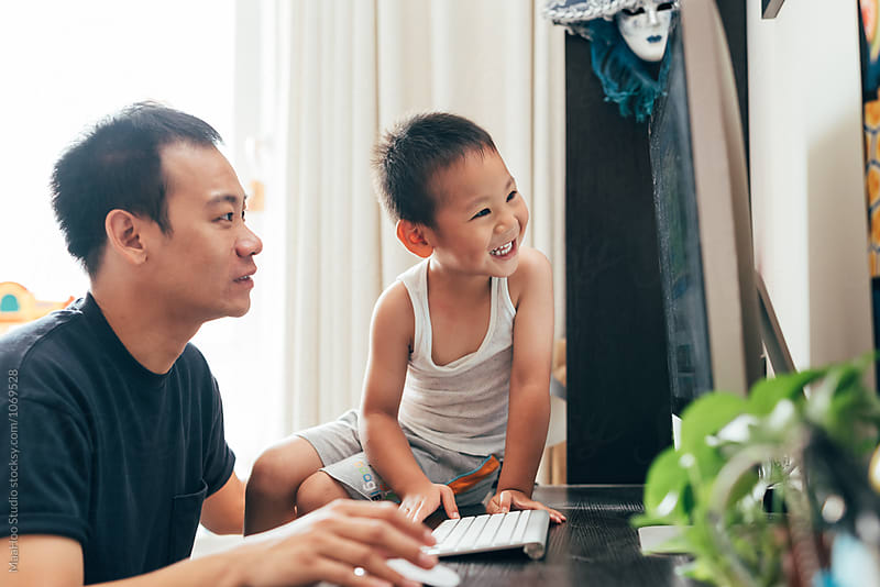Father and son using computer at home