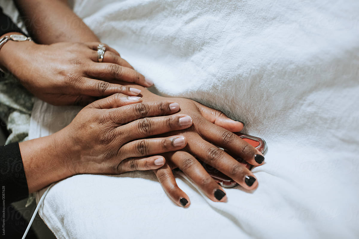 Closeup of Hands as Mother Comforts Daughter in Hospital Bed