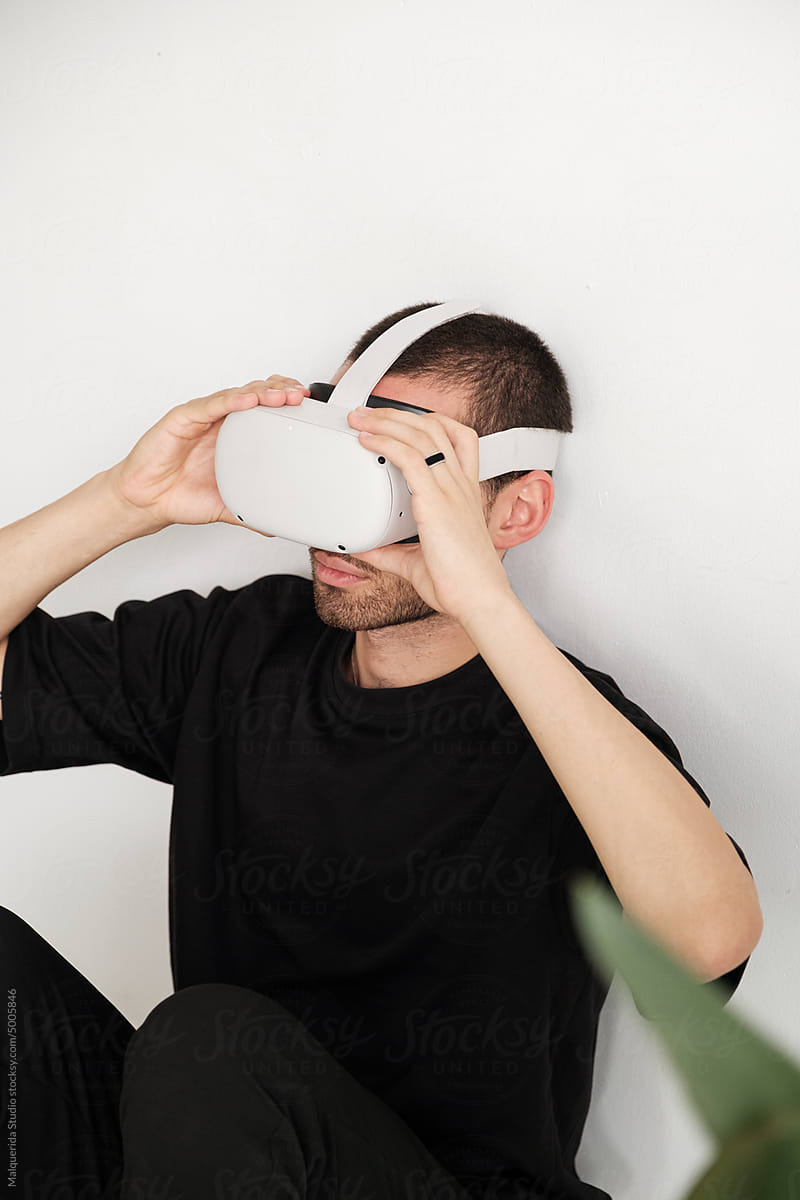 Young man putting on VR glasses