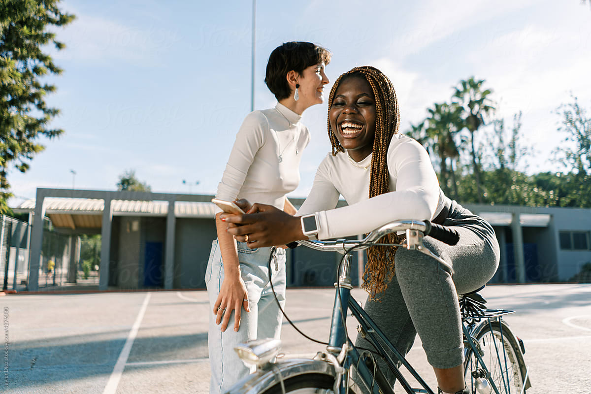 Smiling female friends riding bicycle