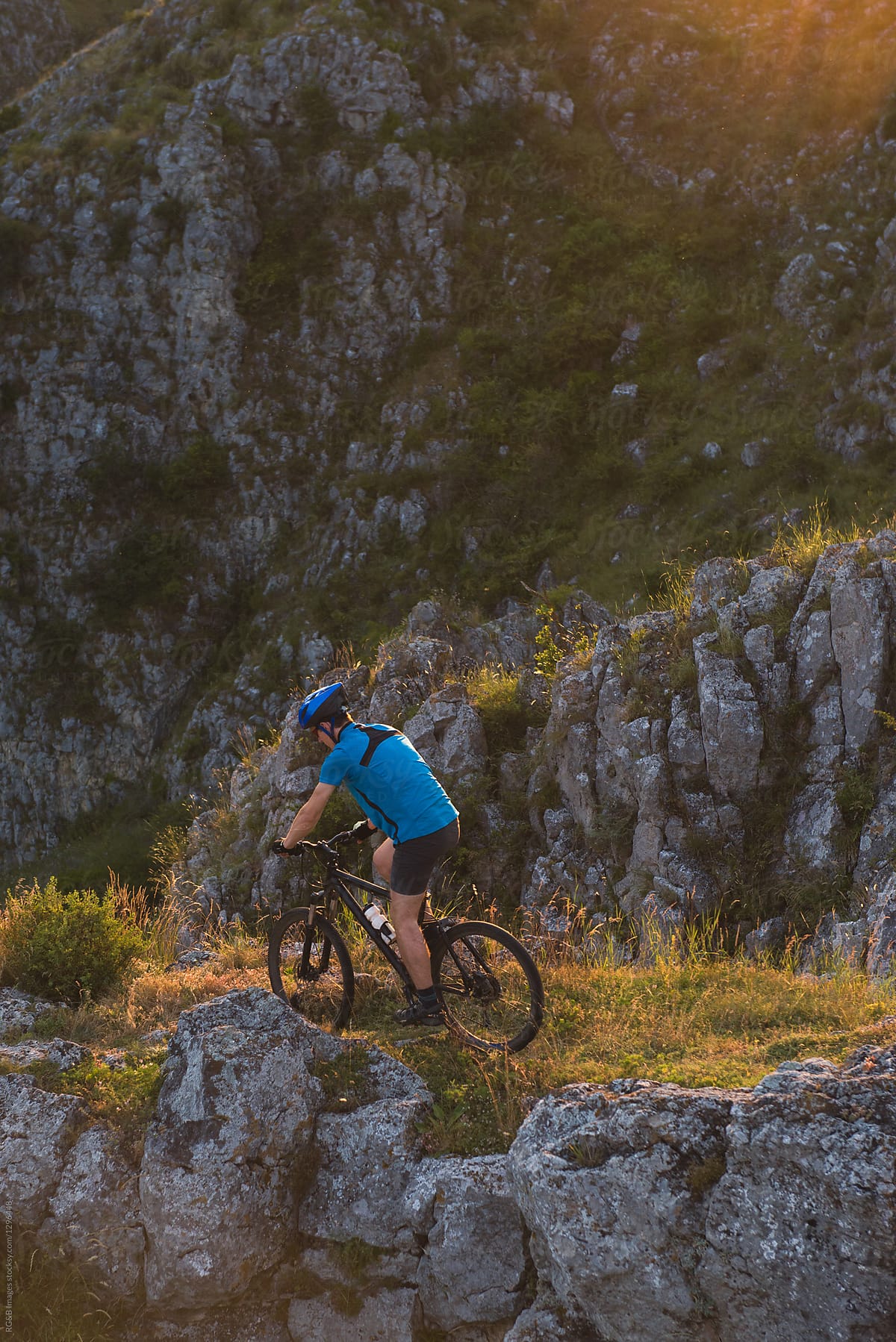 Man riding mtb off road in nature during sunset