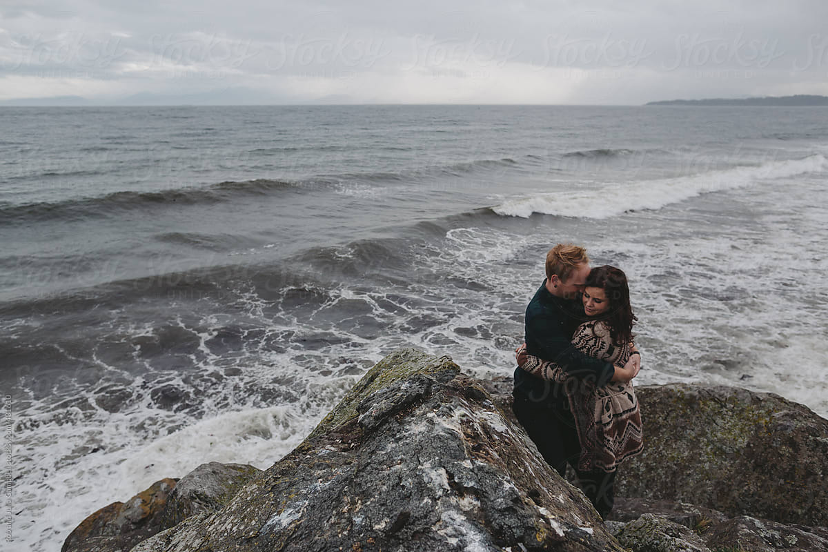 Young, stylish couple hugging together outside in west coast winter