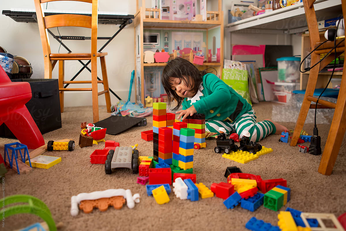 Girl in Christmas pajamas surrounded by playroom toys 3