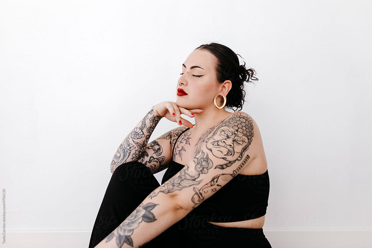 Peaceful tattooed woman in studio