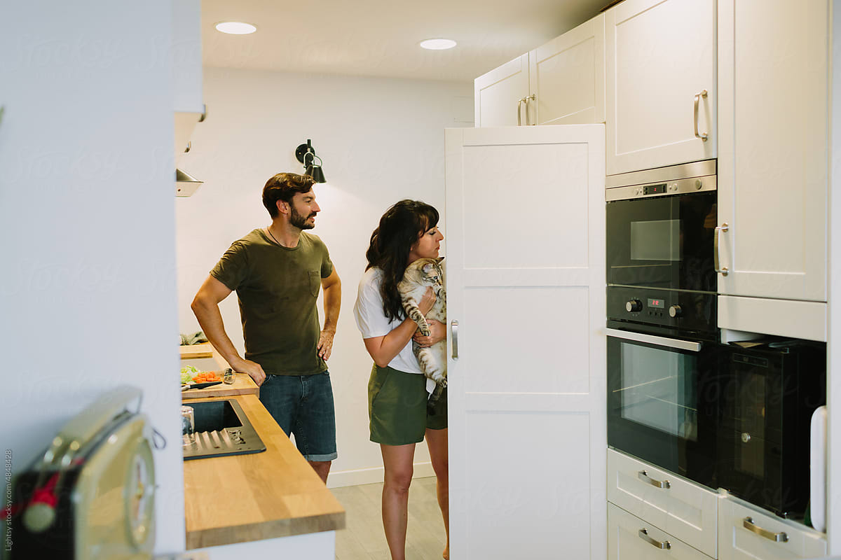 Couple looking into the fridge for cooking