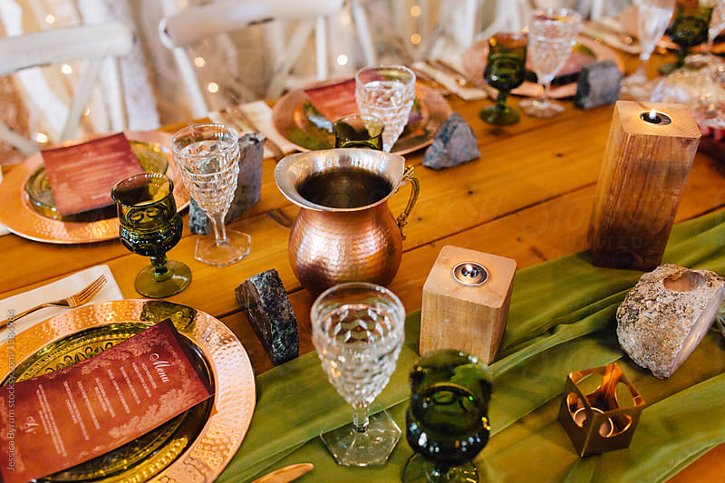 A venue set up for a wedding reception with copper and green colored decor.