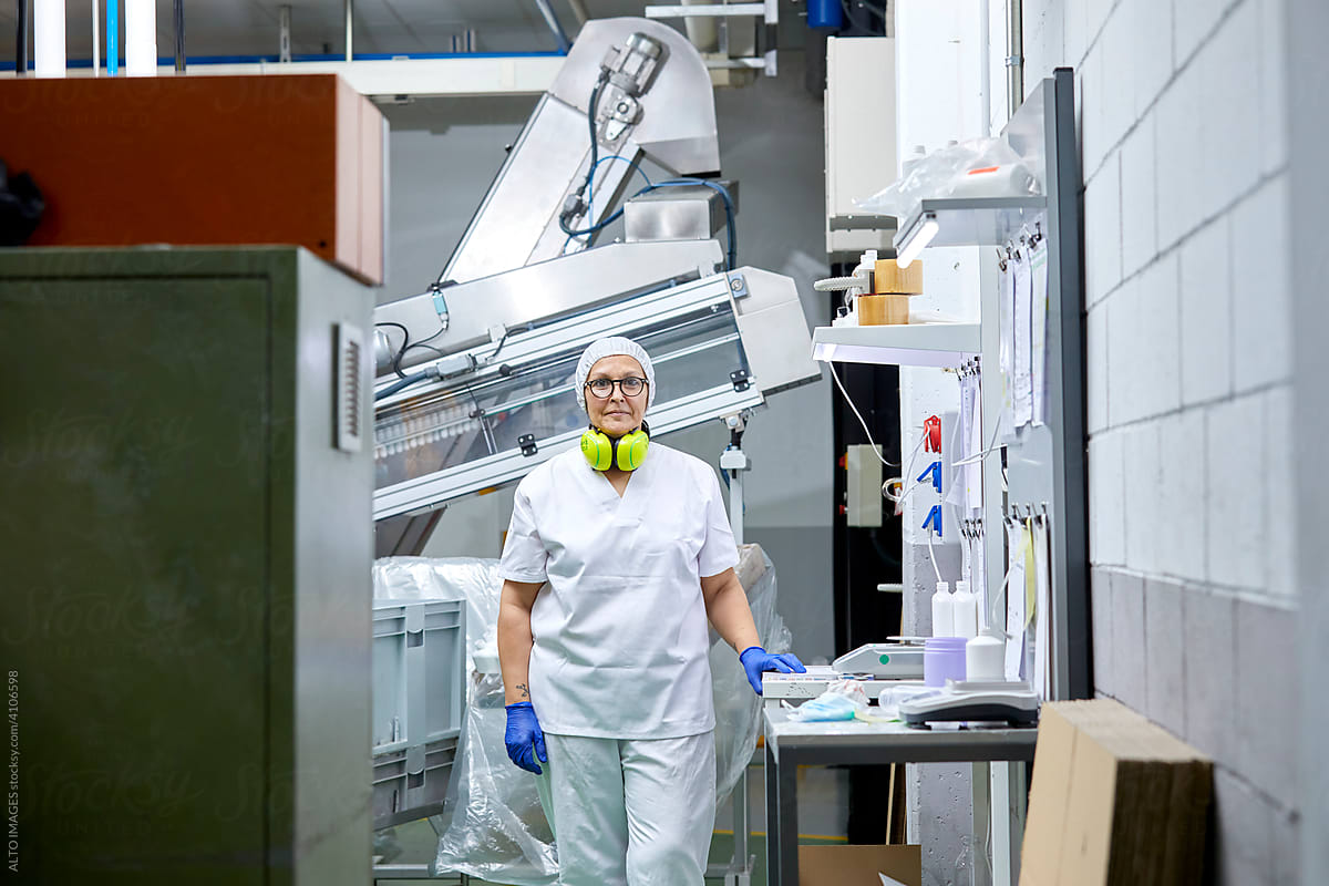 Female employee near conveyor at factory