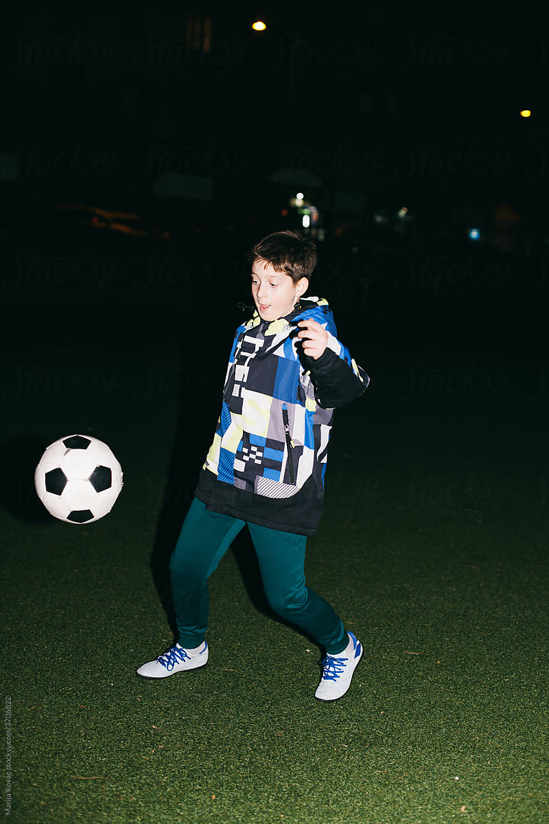 A kid playing with a football ball