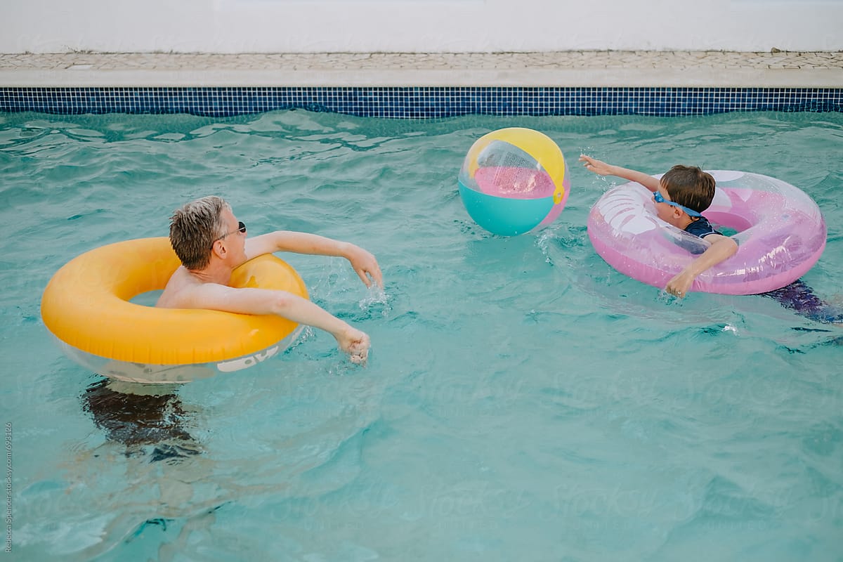 Dad and son on matching inflatable pool rings have fun