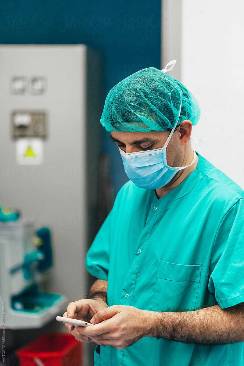 Surgeon holding a phone at the hospital