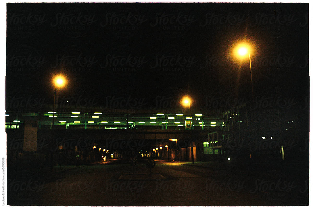 Metro station pedestrian bridge and its green city lights at night
