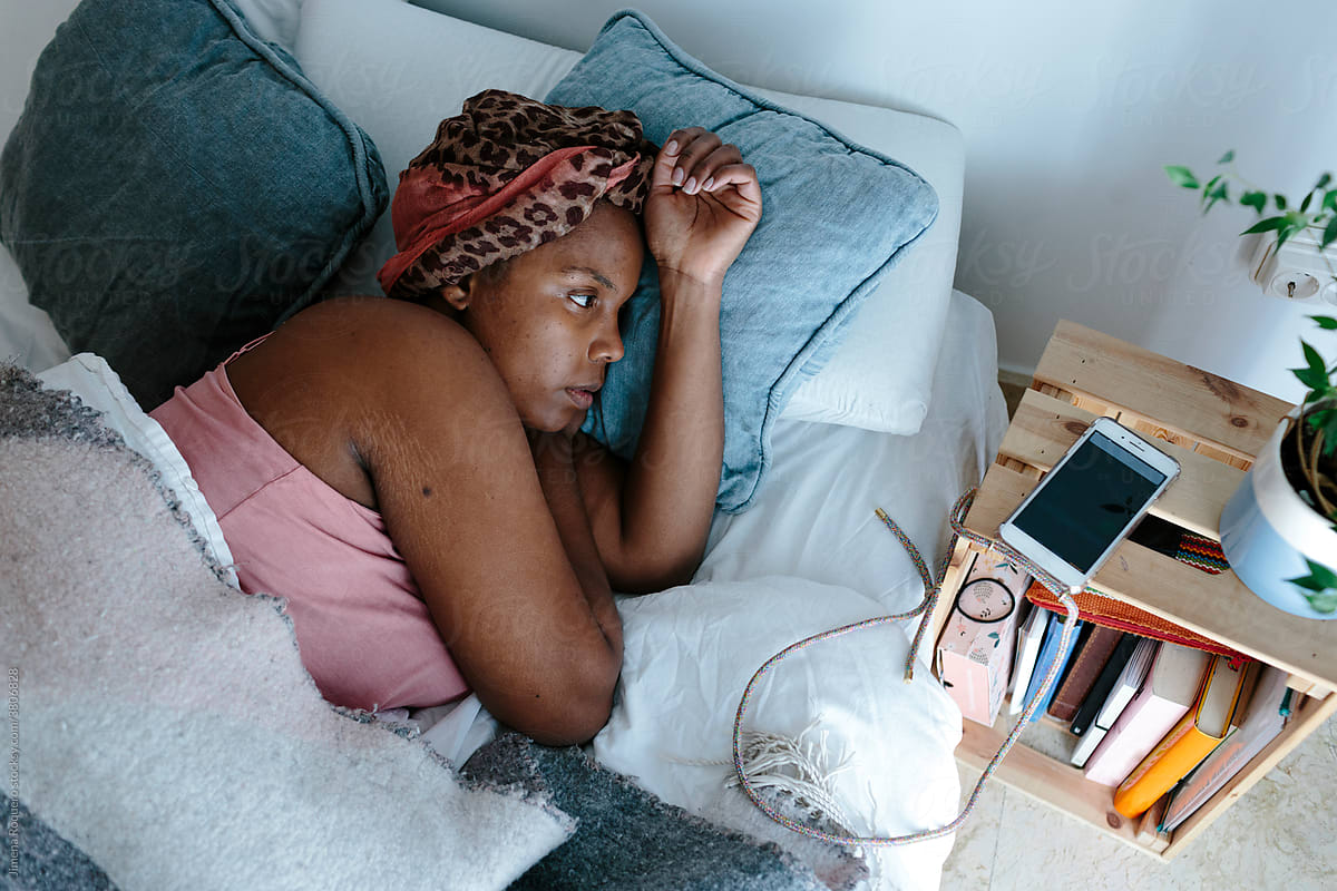 Woman in bed looking at alarm on cell phone