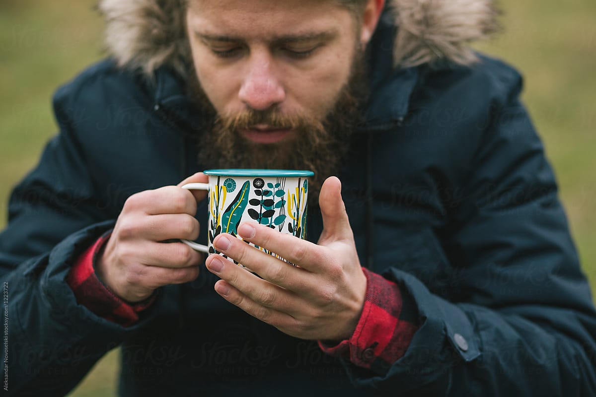 Young man drinking hot tea in the mountain
