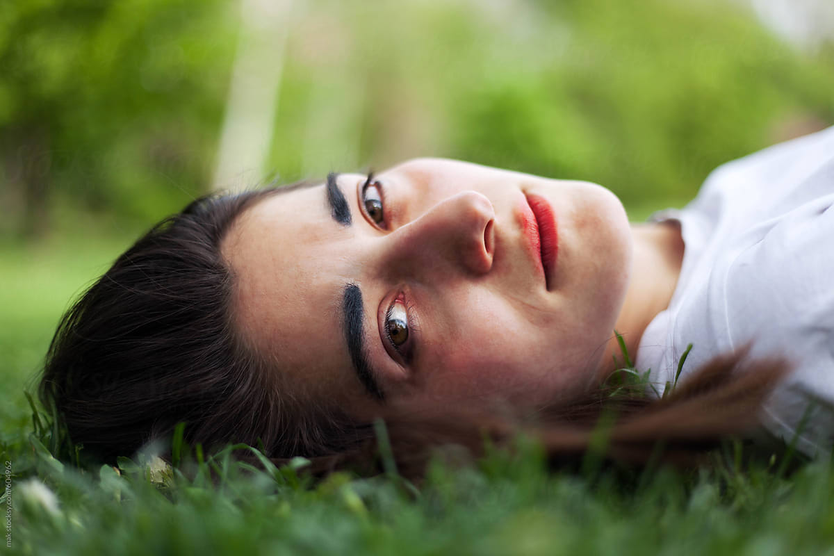 Young Beautiful Woman Lying On A Grass By Stocksy Contributor Mak