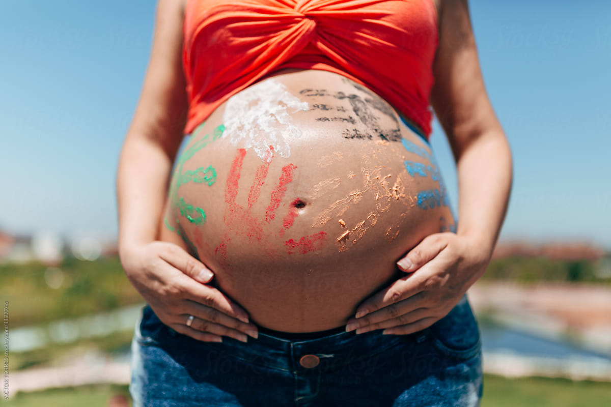 Pregnant belly painted with colored hands