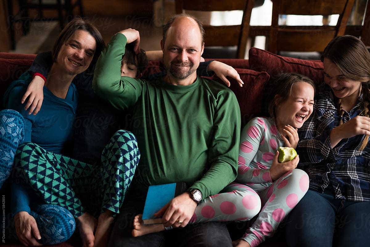 Family fun moment relaxing on sofa in ski chalet