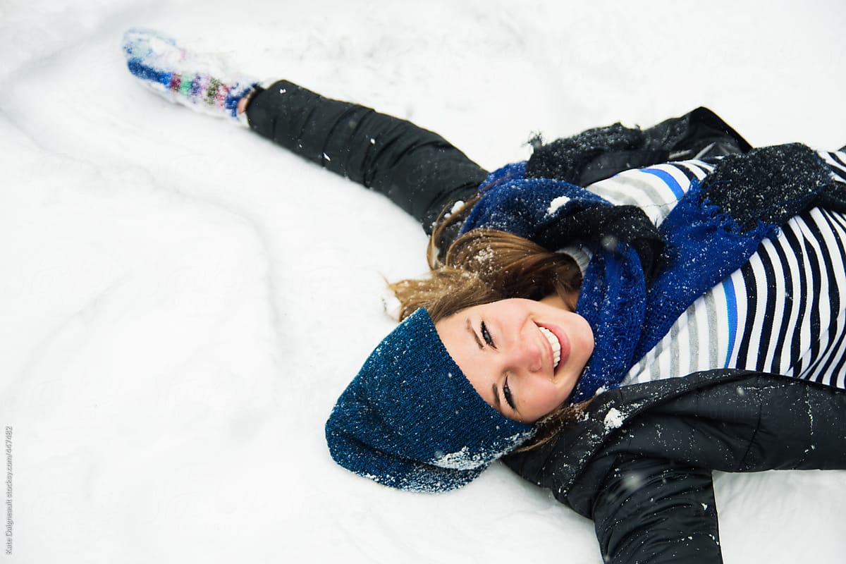 Young woman making snow angel
